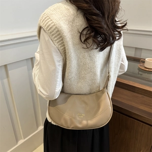 Minimalist beige pebble leather half-moon crossbody bag for women's daily travel use