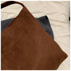 Macro shot of dark brown suede tote bag showing soft texture and premium stitching