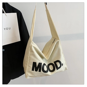 Detail view of the metal zipper closure and thick canvas strap on the beige hobo bag