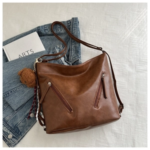 Dettaglio della borsa tote marrone vintage con zip e decorazione a forma di orsetto