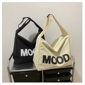 Detail of canvas tote bags with MOOD print, zipper closure and adjustable straps