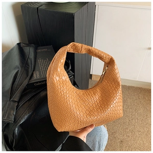 Close-up of caramel woven leather hobo bag with gold zipper detail and hobo style texture