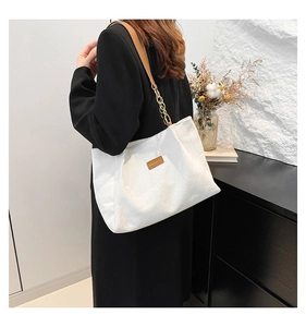 Détail du cabas en velours côtelé blanc avec bandoulière en cuir et chaîne dorée