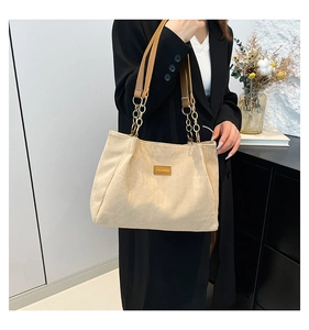 Vue détaillée du sac cabas en velours crème avec étiquette cuir et chaîne dorée