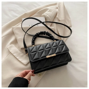 Close-up of quilted handbag featuring a golden clasp and pleated cloud handle
