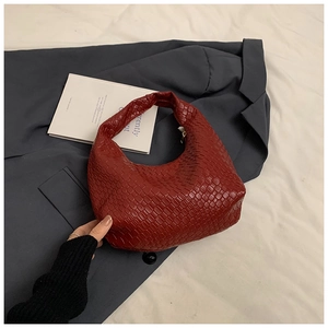 Detailed view of dark red woven leather hobo bag with intricate cross-weave pattern