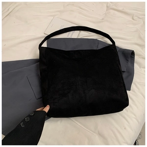 Close-up of black suede tote bag texture with minimalist seamless wide shoulder strap