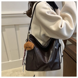 Dettaglio della borsa tote in pelle PU lucida marrone scuro con doppie tasche a cerniera