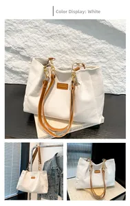 Détail du sac cabas en velours côtelé blanc avec bandoulière en cuir brun et chaîne dorée
