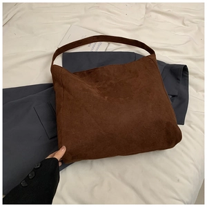Detailed close-up of dark brown matte leather tote bag texture and soft material
