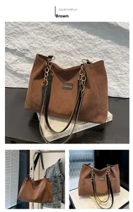 Détail du sac cabas en velours côtelé marron avec étiquette mode et chaîne dorée