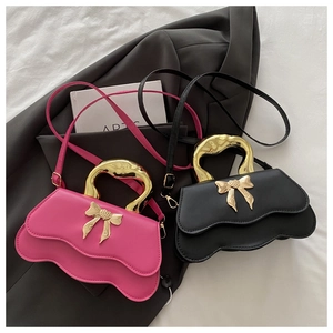 Detail of stylish bow handbags with wavy edges and gold metallic handles in pink and black