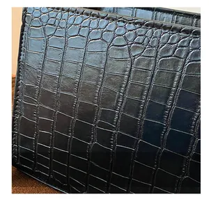 Close-up of black crocodile embossed leather texture with elegant glossy finish