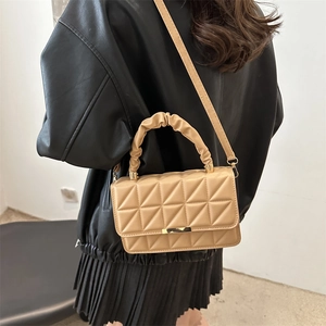 Quilted beige crossbody bag with ruched handle and gold hardware on female model