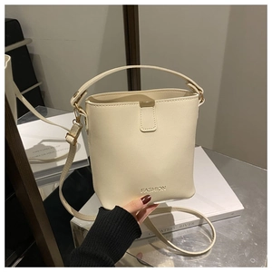 Dettaglio della borsa a secchiello in ecopelle crema con chiusura magnetica e manico