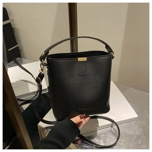 Dettaglio della borsa a secchiello in pelle nera con finiture dorate e logo
