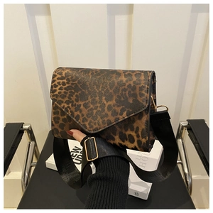 Détail du sac bandoulière léopard avec large sangle en tissu et boucles dorées