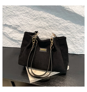 Vue détaillée du sac cabas en velours côtelé noir avec chaîne dorée et texture rayée