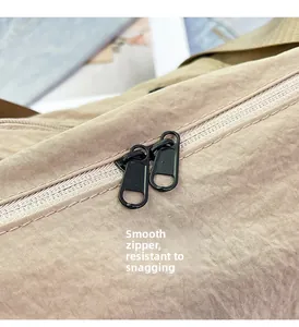 Detail of smooth double zipper on khaki nylon bag ensuring snag-free functionality