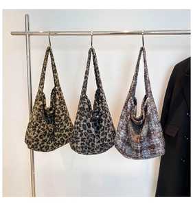 Trois sacs hobo en peluche à imprimé léopard suspendus sur un portant métallique