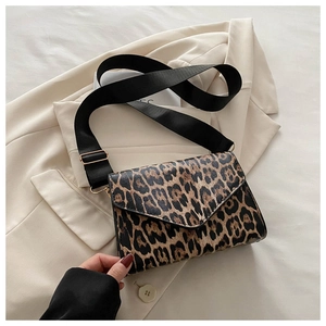 Close-up of leopard print crossbody bag with wide black strap and gold hardware
