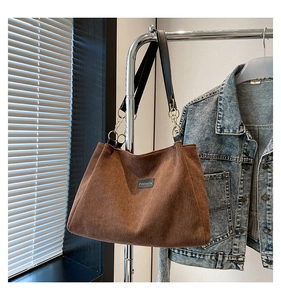 Détail du sac cabas en velours côtelé marron avec étiquette Fashion et chaîne métal