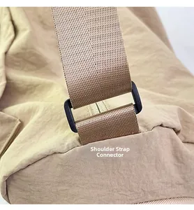 Detail of the shoulder strap D-ring and high-density woven strap on a light khaki nylon bag