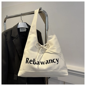 Detail van het Rebawancy-logo en de decoratieve strik op deze witte canvas draagtas
