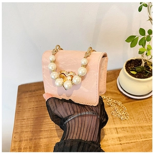 Detail of pink marble pattern mini bag with pearl handle and metal heart clasp