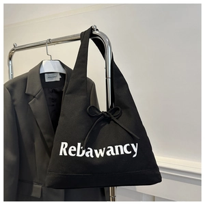 Detail van de zwarte canvas draagtas met Rebawancy-belettering en decoratieve strik