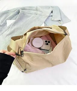 Interior view showing the large capacity of the khaki nylon shoulder bag with items