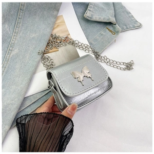 Close-up of silver mini chain bag with metallic butterfly clasp and dual chain strap
