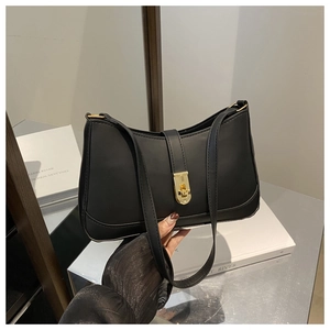 Detail of a black hobo underarm bag featuring a vertical strap and gold metal twist lock