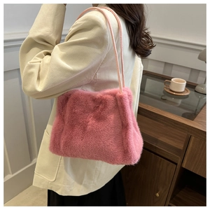 Detail of pink faux fur shoulder bag with soft plush texture and slim straps for winter