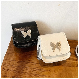 Close-up of crocodile embossed mini crossbody bag with a large silver butterfly buckle