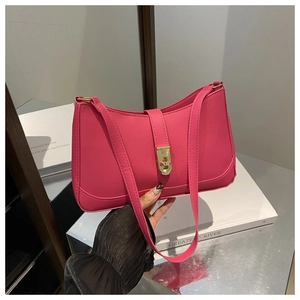 Close-up of a magenta leather underarm bag featuring a stylish gold metal twist lock buckle