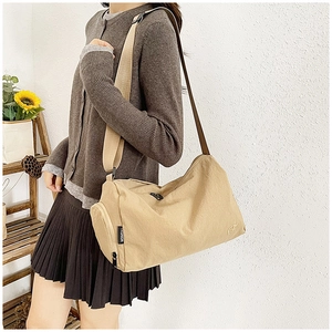 Detail shot of khaki nylon shoulder bag with fashion label on casual outfit