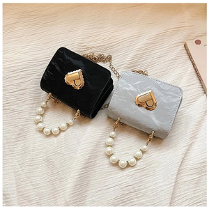 Macro shot of French style mini heart-lock handbags with pearl handles and gold chain straps