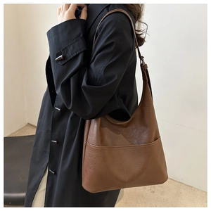 Détail du sac hobo vintage marron avec poche frontale et bandoulière réglable