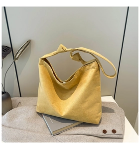 Detail of ginger suede tote bag featuring unique knotted strap and magnetic closure