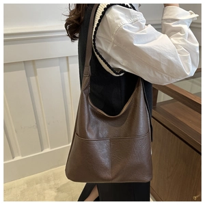 Détail d'un sac à bandoulière en cuir PU marron vintage avec surface texturée et poches