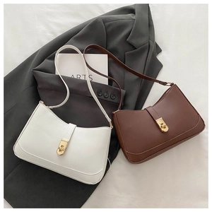 Detailed view of minimalist white and brown leather underarm bags with gold swivel locks