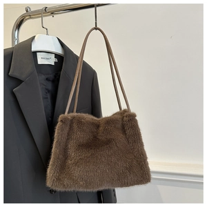 Close-up of soft brown faux fur shoulder bag with slender dark leather straps
