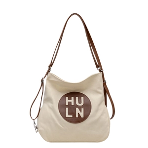 Minimalist canvas tote bag with brown leather strap and embossed circular logo