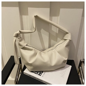 Detail of cream lychee texture hobo bag featuring a stylish knotted shoulder strap