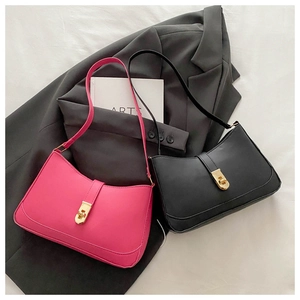 Detailed view of magenta and black underarm bags with elegant golden metallic twist locks