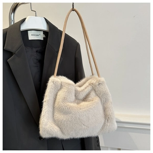 Detail of plush faux fur tote bag in cream white with slender leather shoulder straps