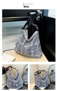 Detail of blue and white geometric canvas tote bag with wide adjustable black strap