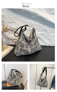 Detail showing the thick canvas weave and wavy pattern texture on this black tote bag