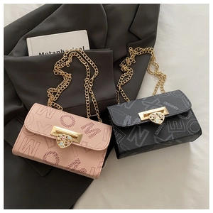 Detail view of pink and black chain bags with heart metal lock and letter patterns
